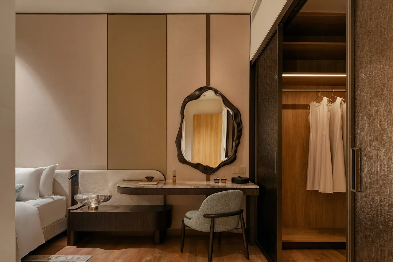 Dressing area with vanity, sculpted mirror and walk-in wardrobe — show unit