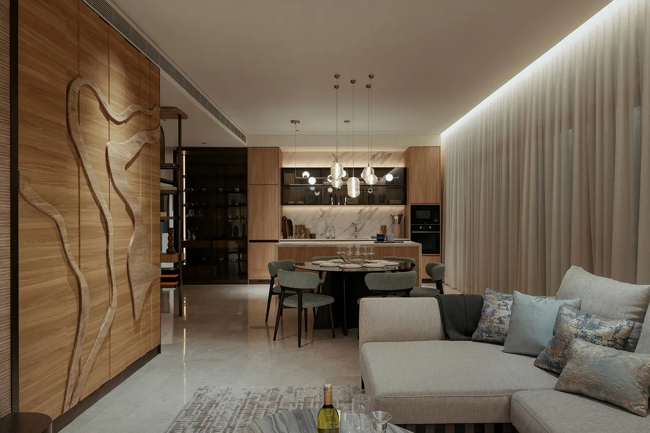 Open-plan living and dining of the show unit, with the carved timber feature wall