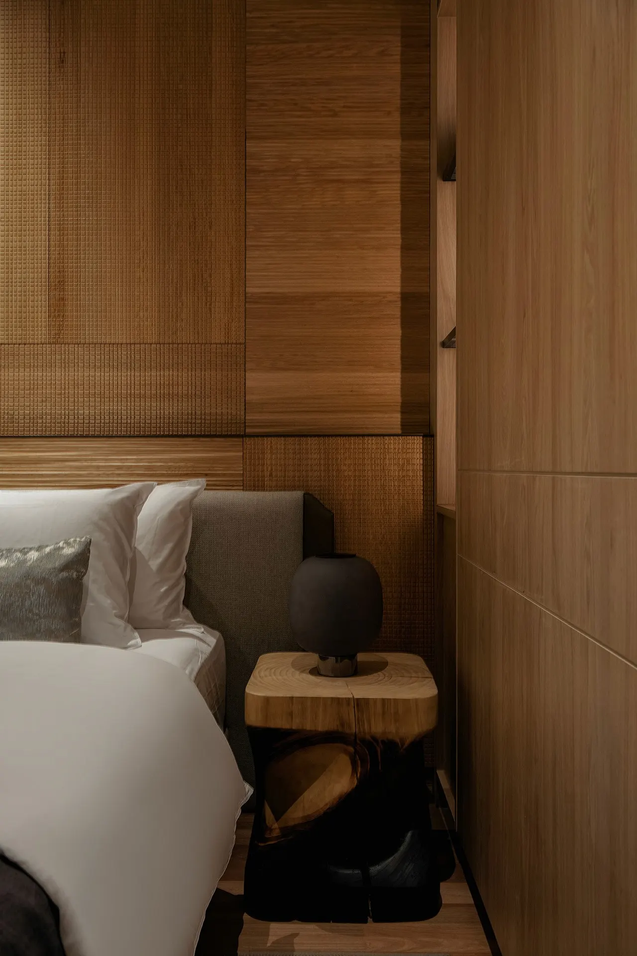 Master bedroom with upholstered headboard and timber-clad walls — show unit
